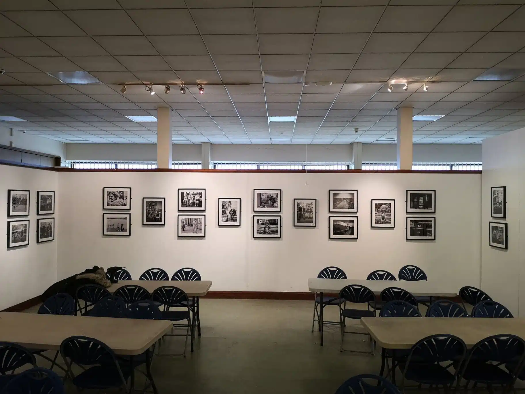 A room with tables and chairs and framed photographs.