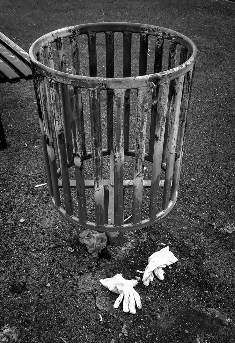 Photographs of the coronavirus lockdown-16 A black and white photo of a trash can with gloves on it.