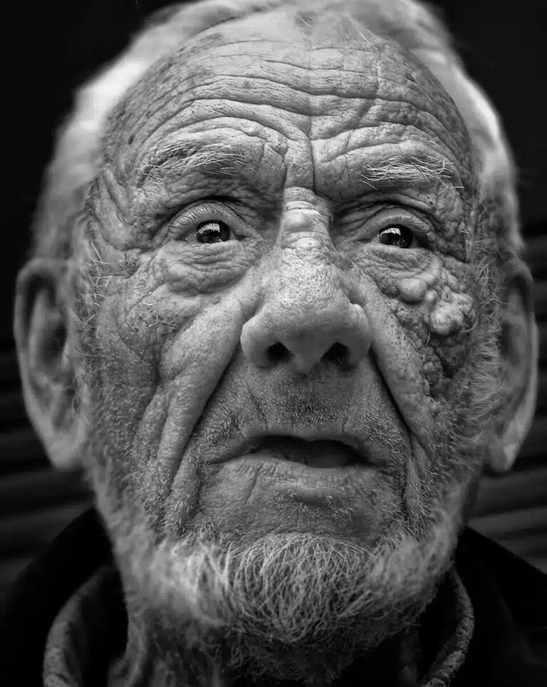 Faces_Photo_by John Gill-34 A black and white photo of an old man.