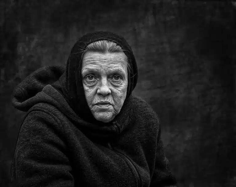 Faces_Photo_by John Gill-36 A black and white photo of an old woman.