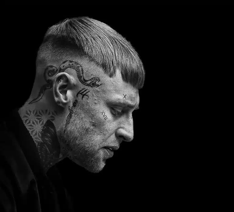 Faces_Photo_by John Gill-38 A black and white photo of a man with tattoos on his head.