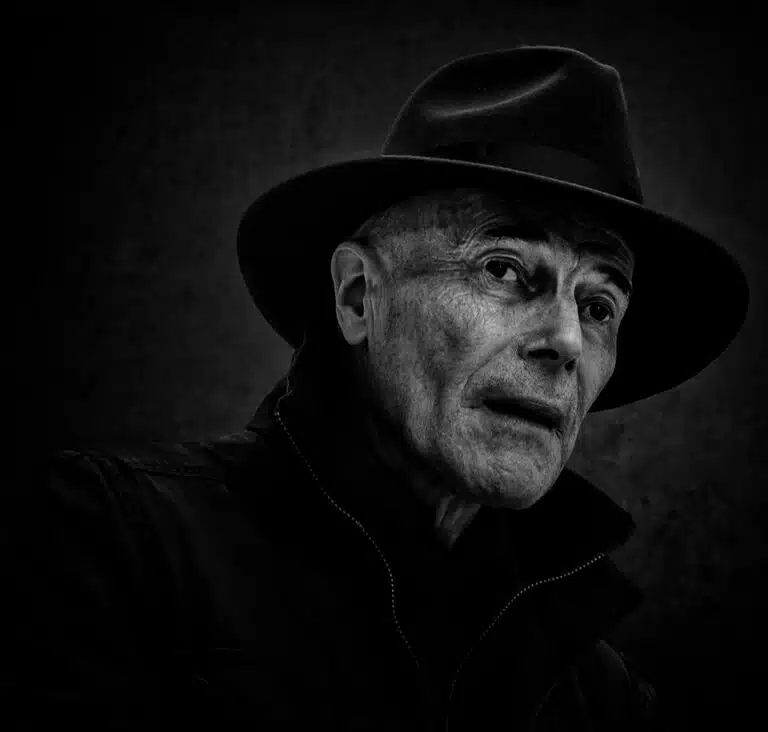 Faces_Photo_by John Gill-39 A black and white photo of a man in a hat.