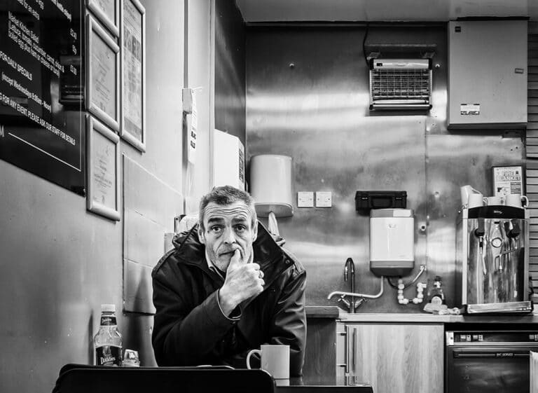 A man sitting at a table in a black and white photo.
