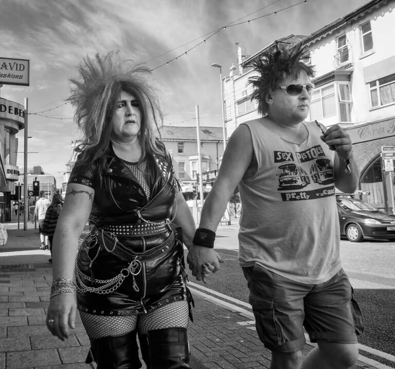 Black and white photo of a couple walking down the street.