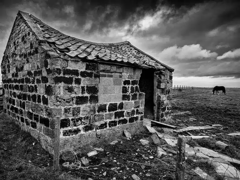 A black and white photo of an old stone building.
