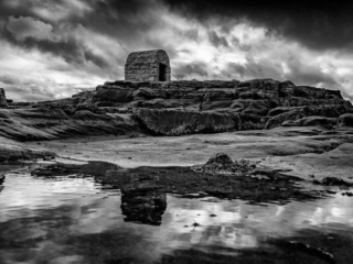 A black and white photo of ruins in the water.