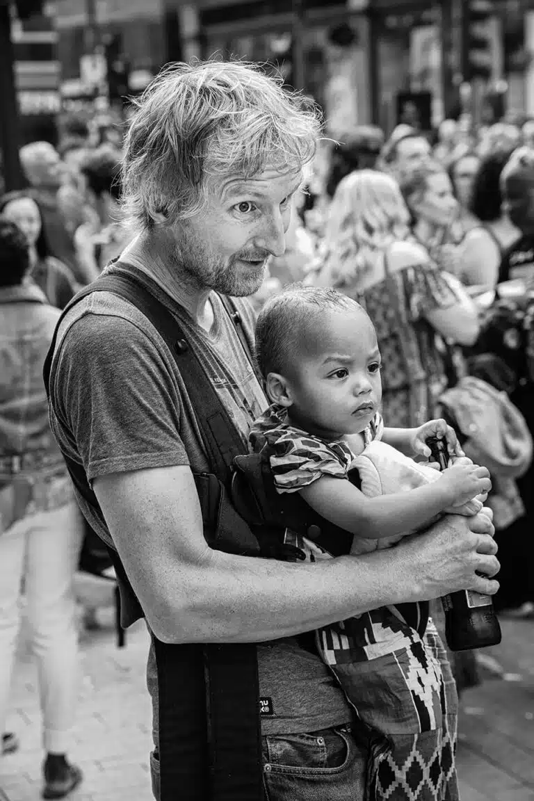 Leeds-Pride-2019-25 A man holding a child in a sling.