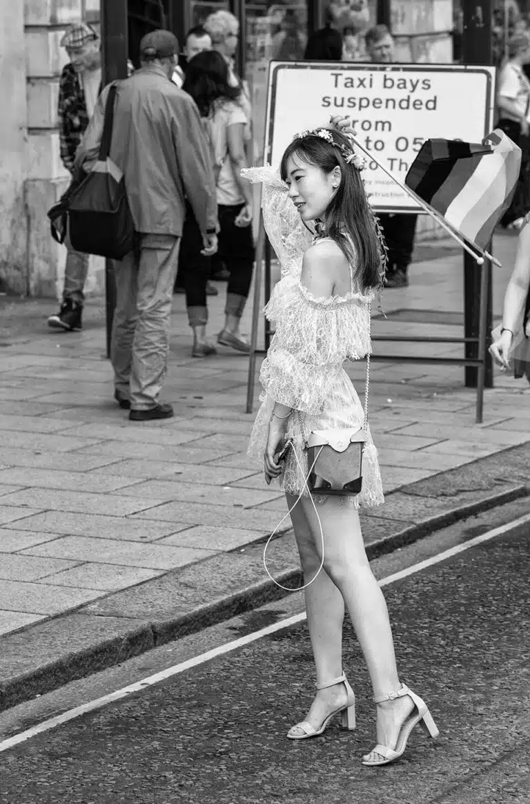 Leeds-Pride-2019-27 Black and white photo of a woman walking down the street with a kite.