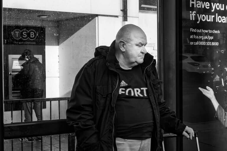 Redcar street photograph-07 Black and white photograph of a man standing in front of an atm.