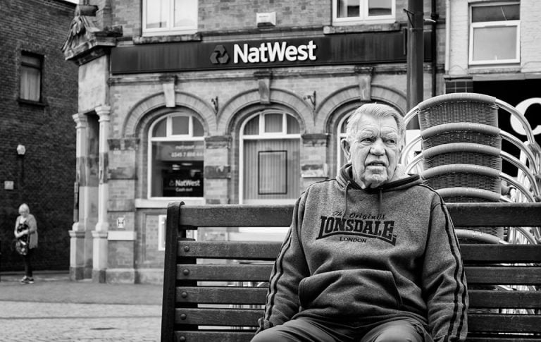 Redcar street photograph-10 A man sitting on a bench.