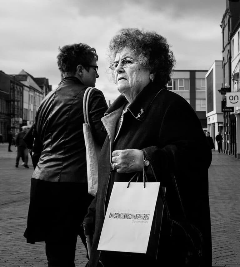 Redcar street photograph-11 A woman with a shopping bag walking down the street.