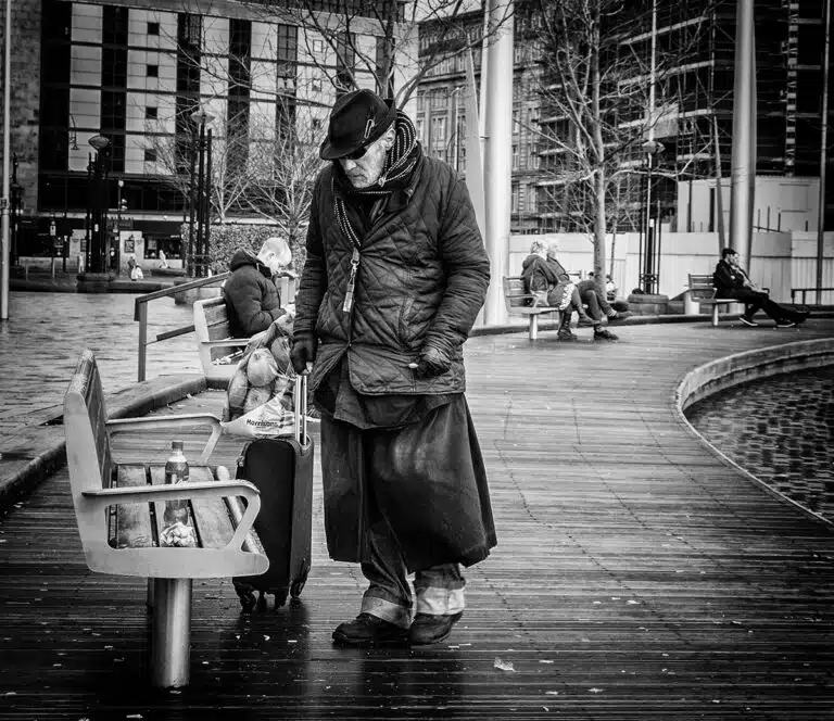 A man with a suitcase on a sidewalk.