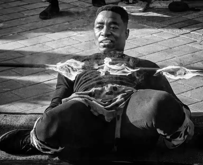 Street_Photography_Leeds_by John Gill-05 A black and white photo of a man sitting on the ground.