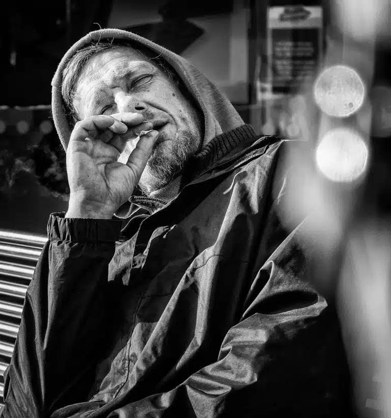 Street_Photography_Leeds_by John Gill-06 A man in a hoodie smoking a cigarette.
