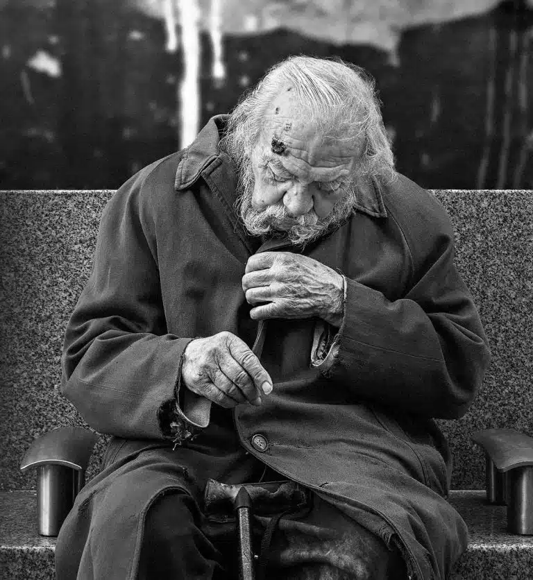 Street_Photography_Leeds_by John Gill-07 An old man sitting on a bench smoking a cigarette.