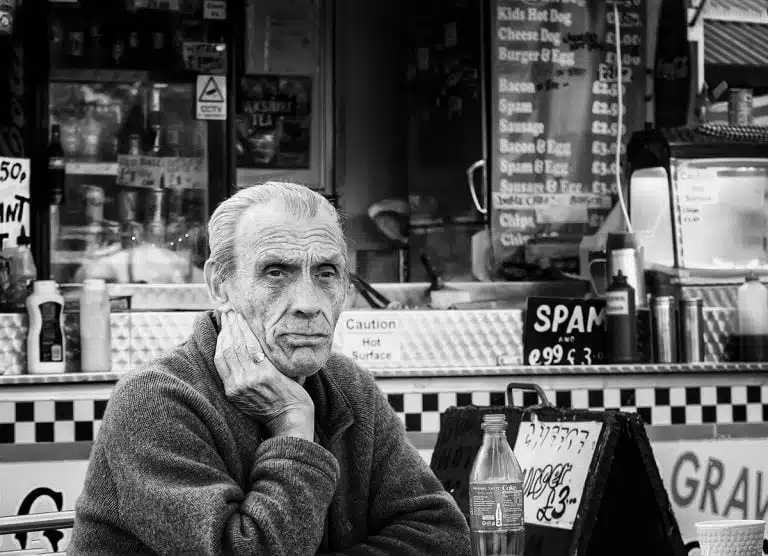 Street_Photography_Leeds_by John Gill-15 An old man sitting in front of a cafe.