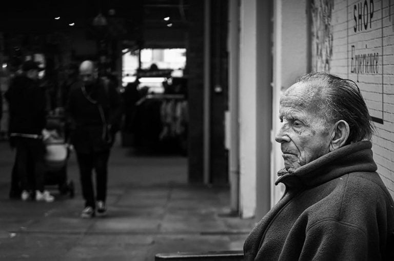 An old man sitting on a bench.