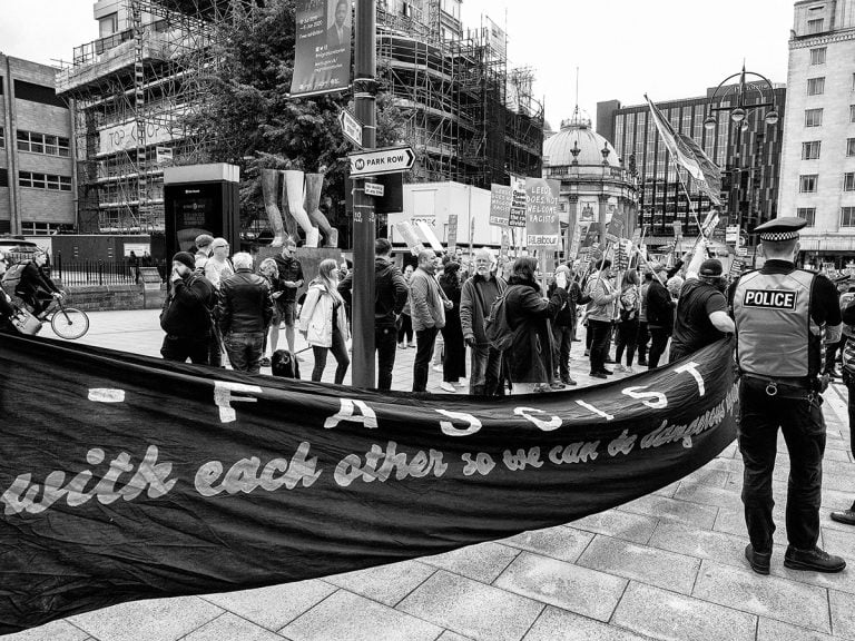 A black and white photo of a group of people holding a banner.