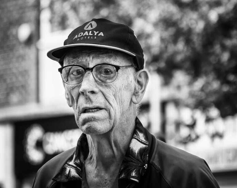 An old man with glasses and a hat.