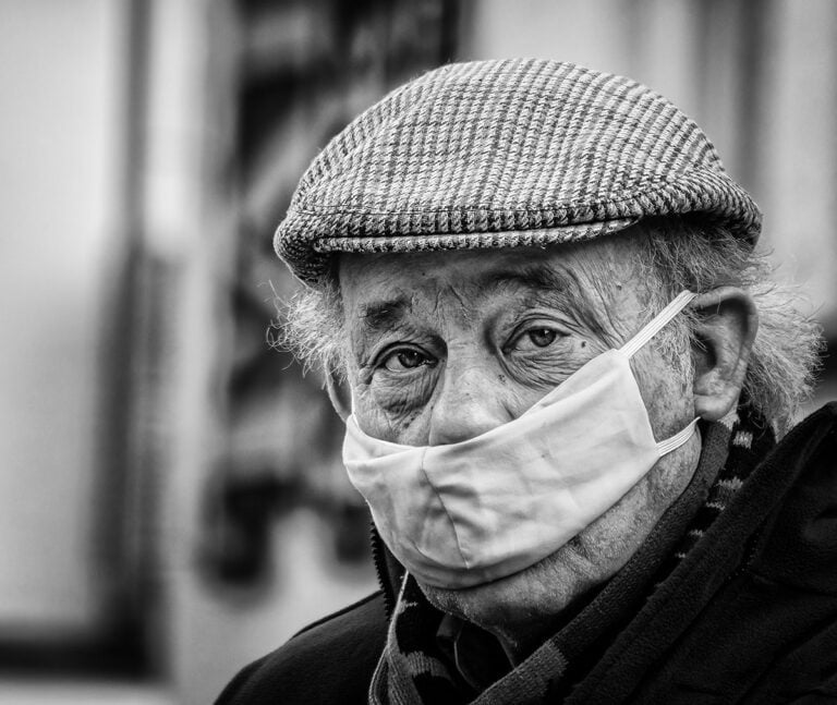 An old man with a surgical mask on his face.