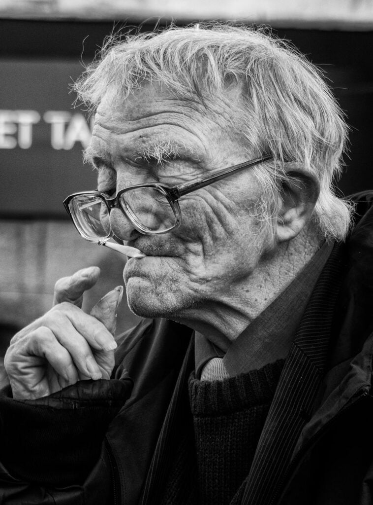 An old man smoking a cigarette.