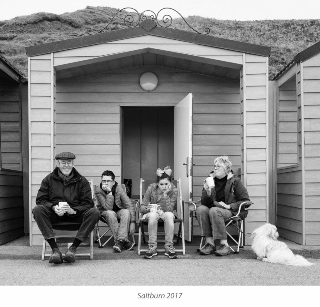 A family sat outside outside chalets, Saltburn