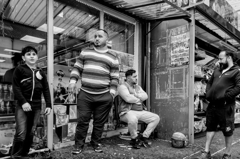 A group of men standing in front of a store.