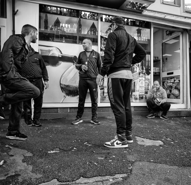 A group of people standing in front of a store.