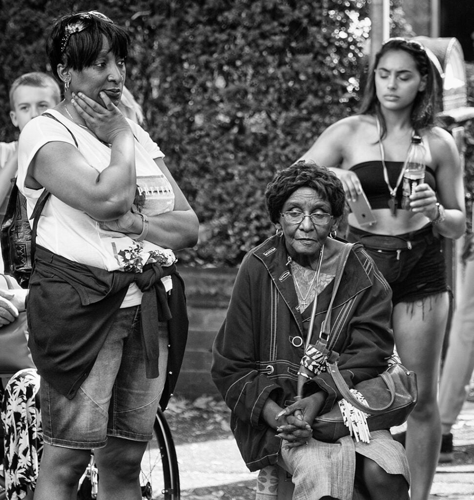 A woman is sitting on a bench next to a woman. A woman is sitting on a bench next to a woman.