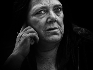 A black and white photo of a woman talking on the phone.