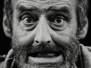 A black and white photo of a man with a beard.