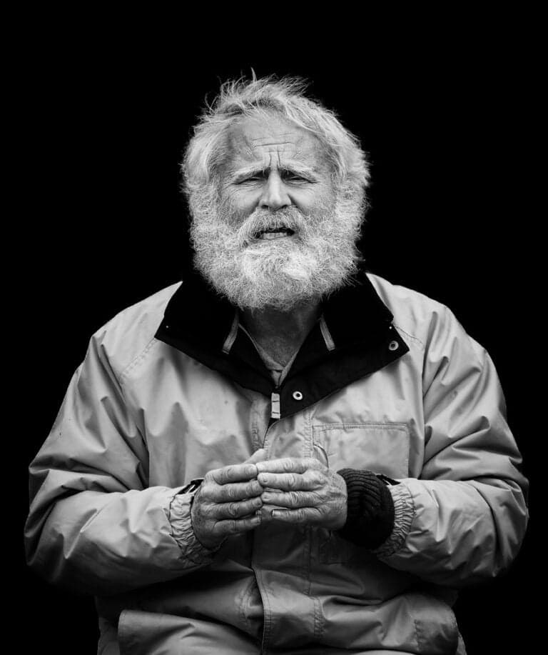 An old man with a beard sitting on a chair. An old man with a beard sitting on a chair.
