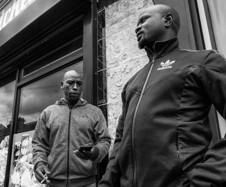 Two men standing in front of a store.