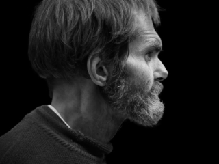 A black and white photo of a man with a beard.