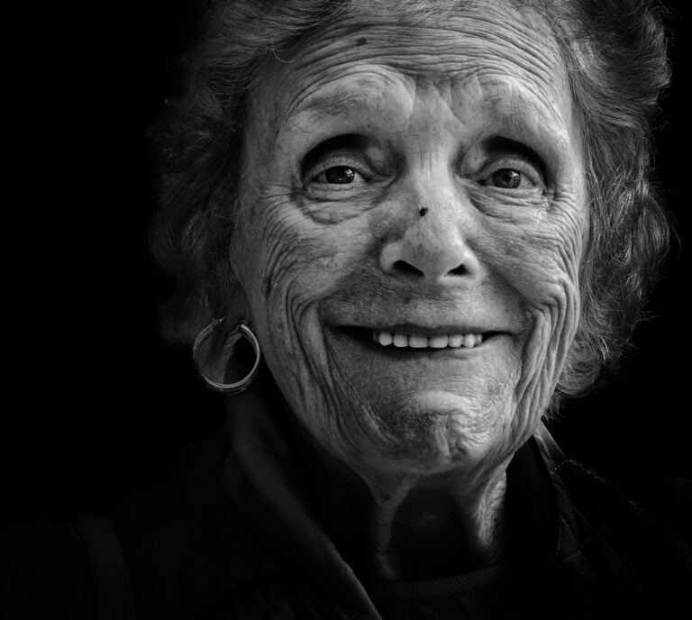 A black and white photo of an old woman smiling. A black and white photo of an old woman smiling.