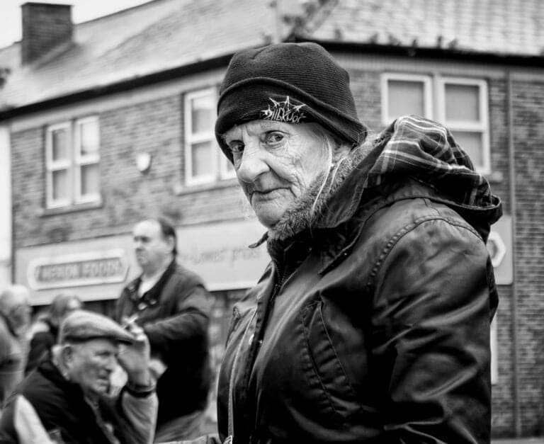 Black and white photograph of an old woman in a hat.