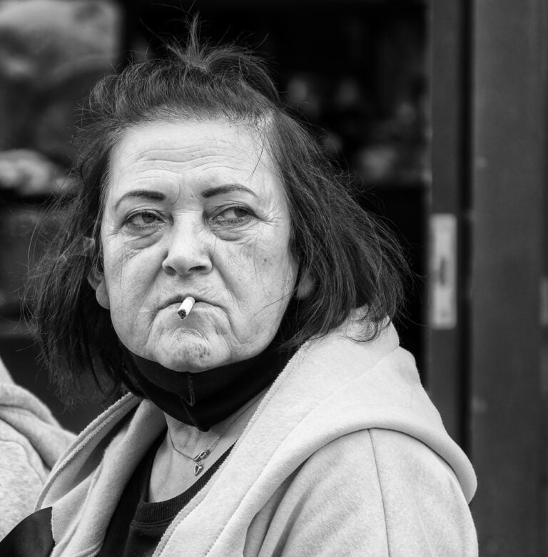 A black and white photo of a woman smoking a cigarette.