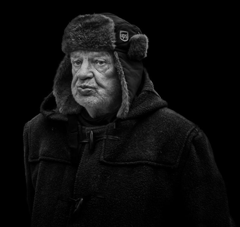 A black and white photo of an old man wearing a fur hat. A black and white photo of an old man wearing a fur hat.