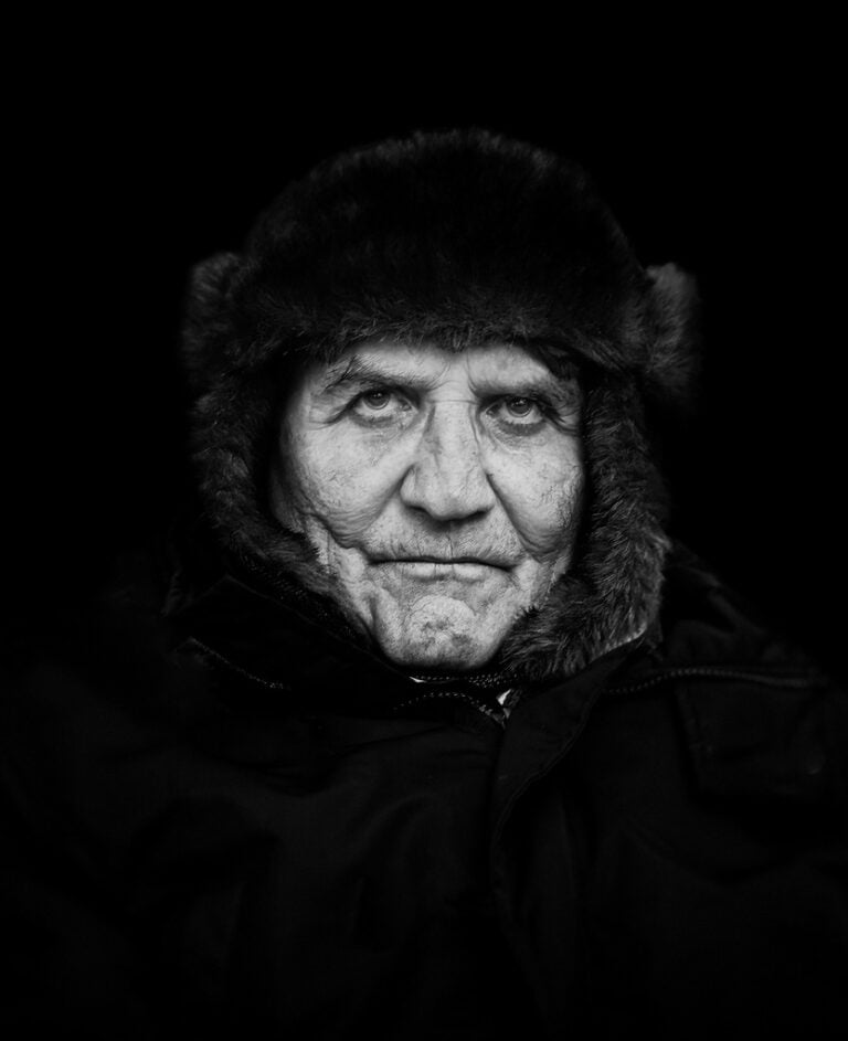 A black and white photo of an old man in a fur coat. A black and white photo of an old man in a fur coat.