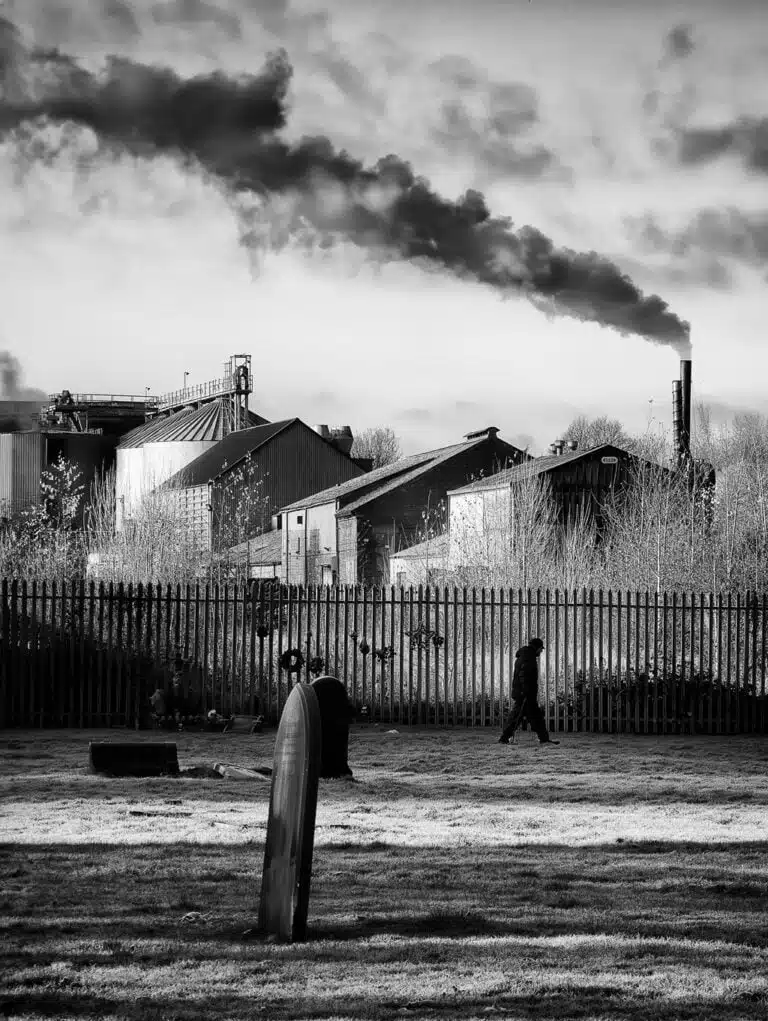 A black and white photo of a cemetery with smoke coming out of it.