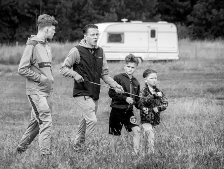A black and white photograph of a group of people walking in a field.