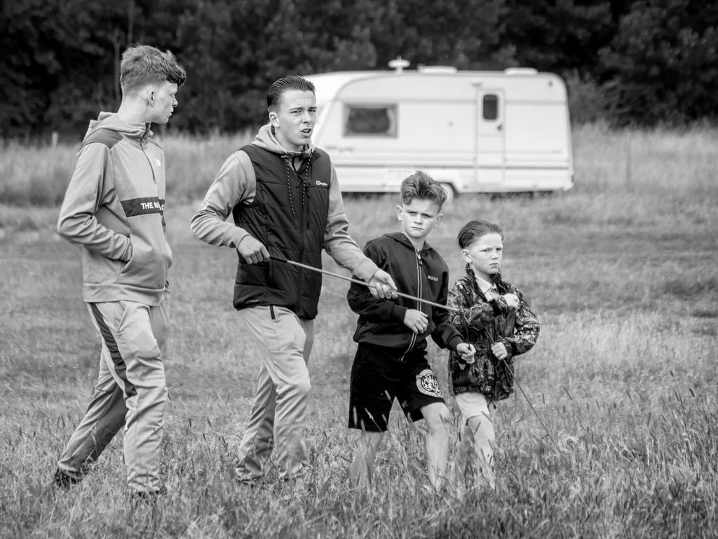 A black and white photograph of a group of people walking in a field.