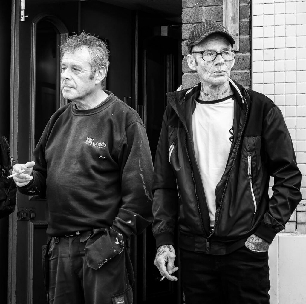 Three men standing outside of a building.
