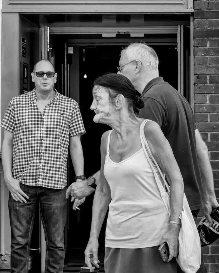 Black and white photograph of a group of people in front of a building.