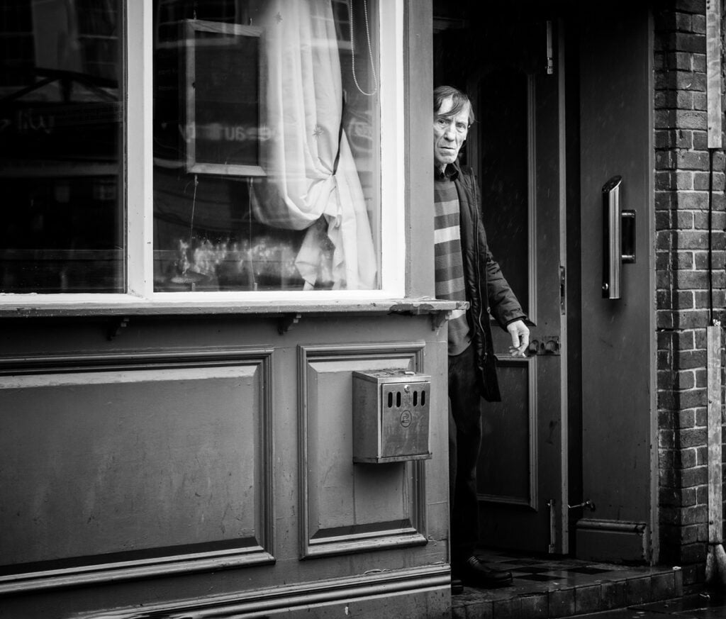 A man standing in the doorway of a shop.