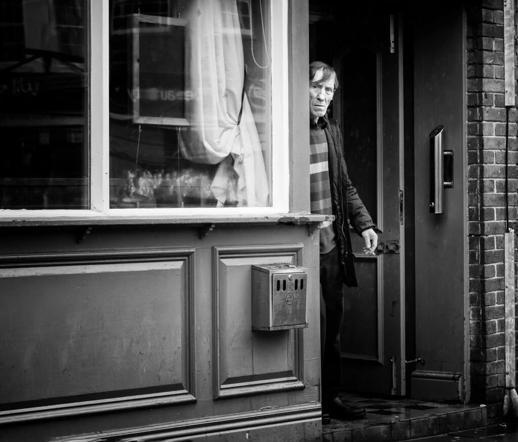 A man standing in the doorway of a shop.