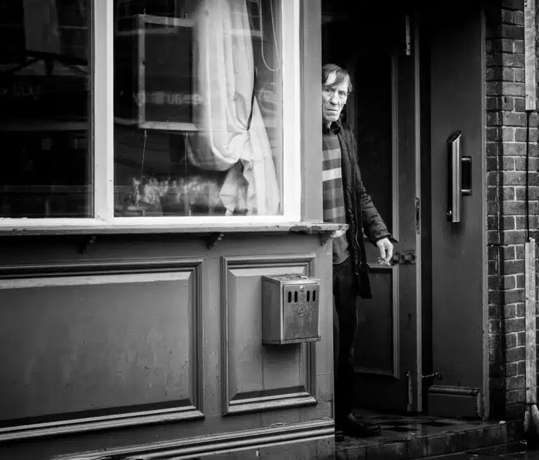 A man standing in the doorway of a shop.