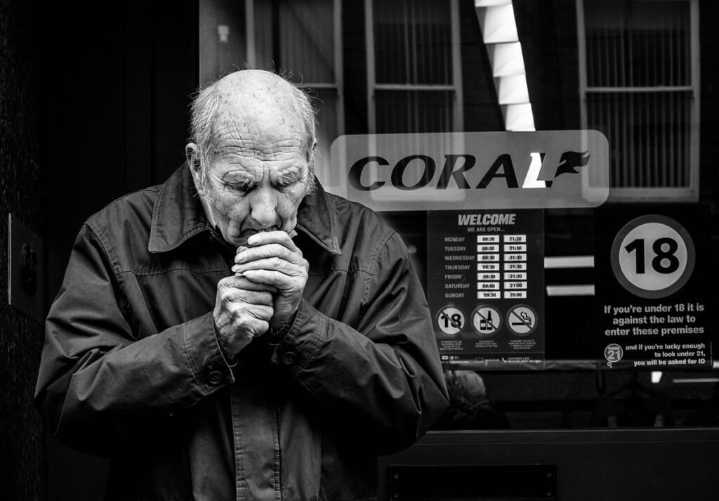 A man smoking a cigarette in front of a store.