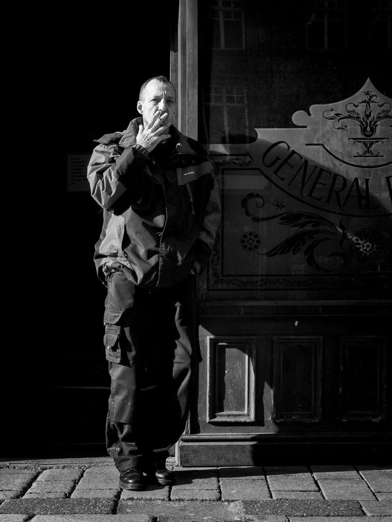 A man is standing in front of a building.