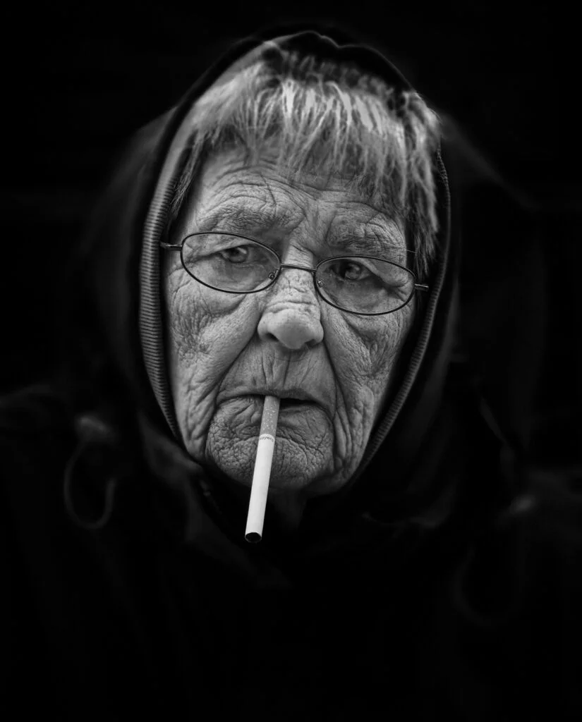 An old woman with a cigarette in her mouth.